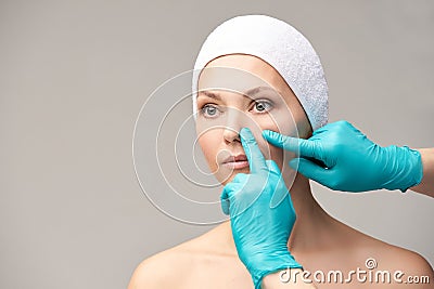 Female derma rejuvenate treatment. Doctor in gloves touch woman face. Cosmetology pretty portrait. Facial nosr injection patient Stock Photo