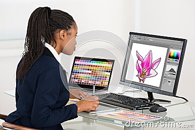 Female Designer Drawing Flower On Computer Using Graphic Tablet Stock Photo