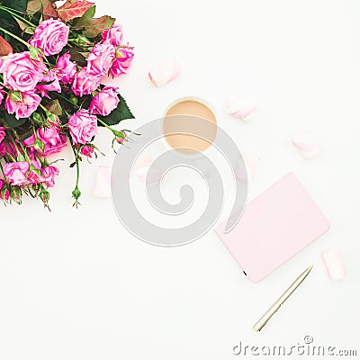 Female desk with pink roses bouquet, pink diary, coffee mug and marshmallows on white background. Flat lay. Top view feminine back Stock Photo