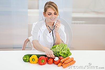 Female dietician examining vegetables Stock Photo