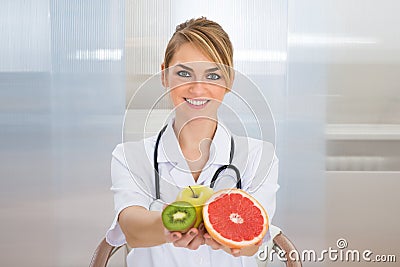 Female dietician holding fruits Stock Photo