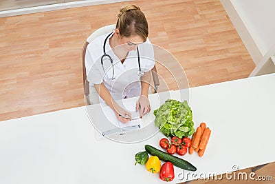 Female dietician writing in diary Stock Photo