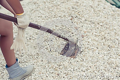 Female diggings stone for the cement with hoe. Stock Photo