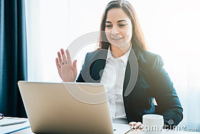 Female distant teacher or friend making video call and talking, looking at laptop webcam, online chat or business Stock Photo