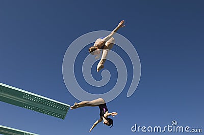 Female Divers Diving In Midair Stock Photo