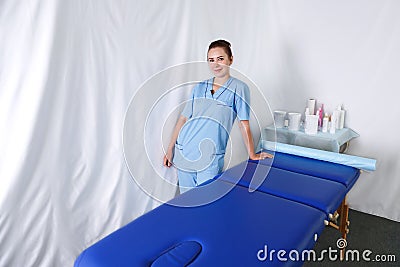 A female doctor beautician is next to the massage table Stock Photo