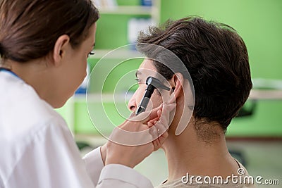The female doctor checking patient`s ear during medical examination Stock Photo