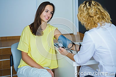 Female doctor checking young woman blood pressure Stock Photo