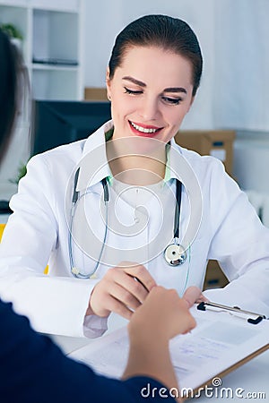 Female doctor consulting patient how to fill application form . Stock Photo