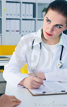 Female doctor consulting patient how to fill application form . Stock Photo