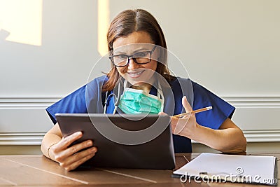 Female doctor counseling, helping patient online, medic using digital tablet for video call Stock Photo