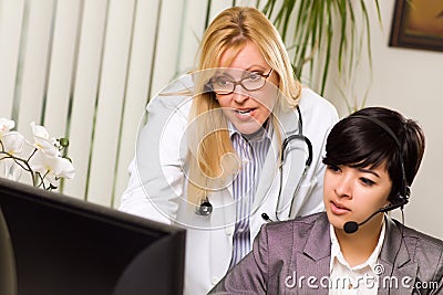 Female Doctor Discusses Work with Receptionist Stock Photo