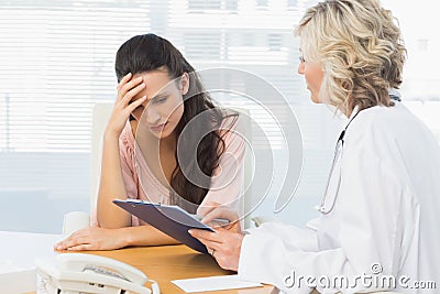 Female doctor discussing reports with patient Stock Photo