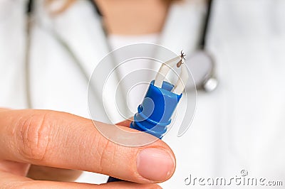 Female doctor is holding tweezers with a tick Stock Photo