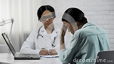 Female doctor informs about bad diagnosis, patient upset incurable disease Stock Photo