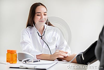 The female doctor measured blood pressure, the patient examined the heartbeat and sat down to talk about health care closely. Stock Photo