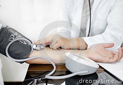 The female doctor measured blood pressure, the patient examined the heartbeat and sat down to talk about health care closely. Stock Photo