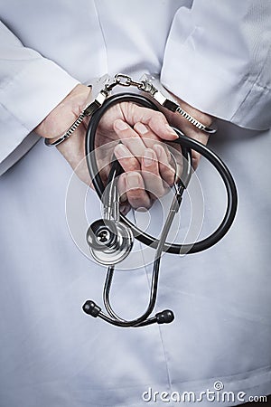 Female Doctor or Nurse In Handcuffs Holding Stethoscope Stock Photo