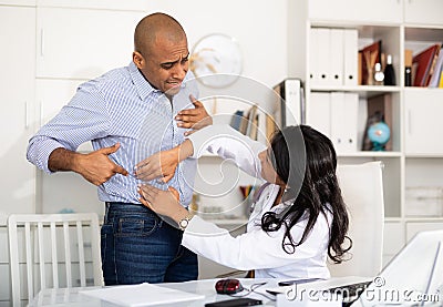 Female doctor palpating abdomen of patient in medical office Stock Photo