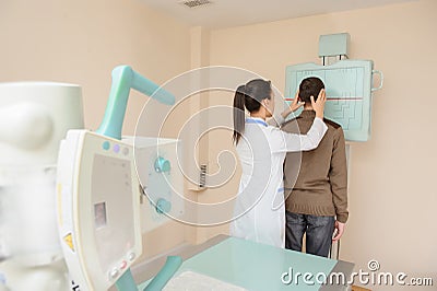 Female doctor preparing the patient for paranasal sinuses x-ray Stock Photo