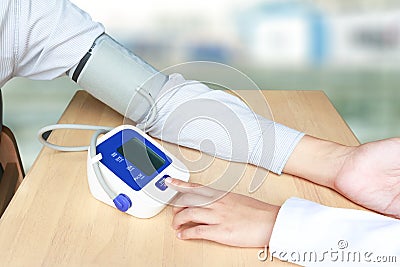 Female doctor press start button on blood pressure or sphygmomanometer - health concept. Stock Photo