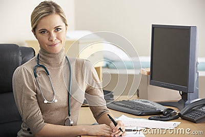 Female Doctor sitting at desk Stock Photo