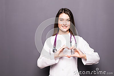 Female doctor smile and make her hand to heart shape on grey Stock Photo