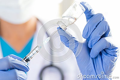 Female doctor with a stethoscope on shoulder holding syringe and Stock Photo