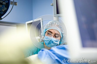 Female Doctor in Surgery Operating Hospital Room. Surgeon medic in protective work wear gloves, mask and cap Stock Photo