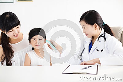 Female doctor Taking temperature using in ear thermometer Stock Photo