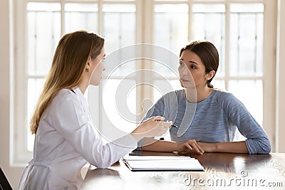 Female doctor therapist consulting young woman at medical appointment Stock Photo