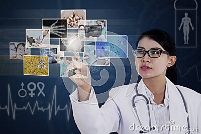 Female doctor touching photos on blue touchscreen Stock Photo