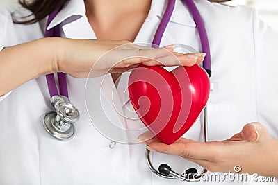 Female doctors's hands holding red heart Stock Photo