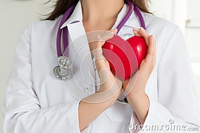 Female doctors's hands holding red heart Stock Photo