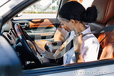 Female driver buckling safety belt Stock Photo
