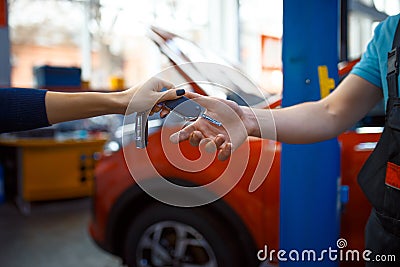Female driver gives keys to worker in uniform Stock Photo