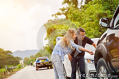 A female driver and a male driver sufferer point out the damage on car after accident on roadside Stock Photo