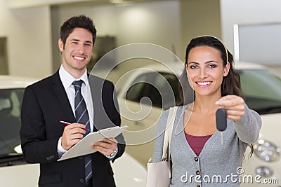 Female driver showing a key after bying a new car Stock Photo