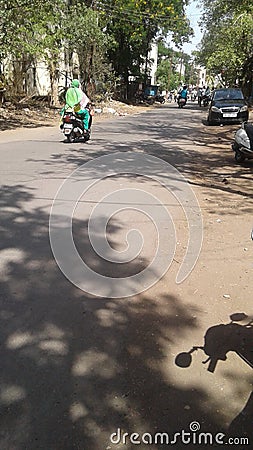 Female driving motorcycle in sunny Streets Editorial Stock Photo