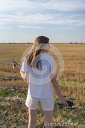 The female drone pilot walks into the field and inspects before the flight. Drone in women`s hands Stock Photo