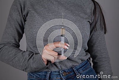 Female drug addict hand syringe. Gray background Stock Photo