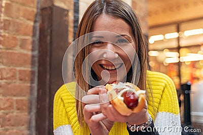 Happy woman eating a hot dog Stock Photo