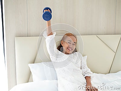Female elderly senior one person caucasian look at camera holding dumbbell activity fitness sport exercise aerobic gym happy smile Stock Photo