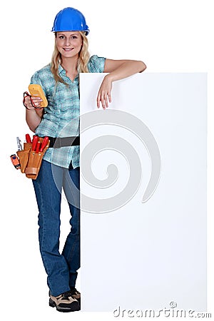 Female electrician standing with advertising Stock Photo
