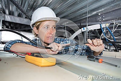 Female electrician working on false ceiling Stock Photo