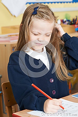 Female Elementary Pupil Suffering From Head Lice In Classroom Stock Photo