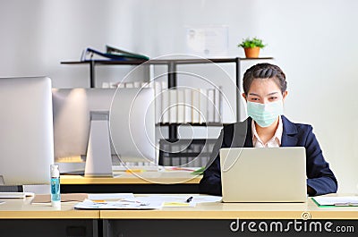 Female employee wearing medical face mask while working in the business office Stock Photo