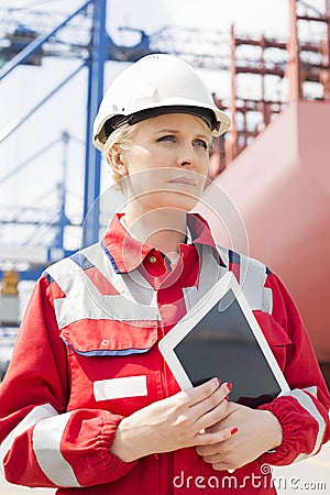 Female engineer holding tablet computer in shipping yard Stock Photo