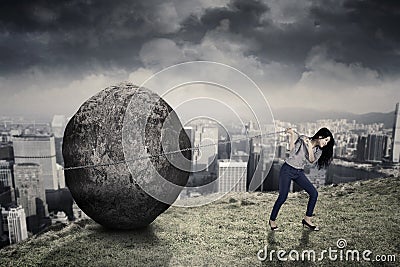 Female entrepreneur with big stone on the hill Stock Photo