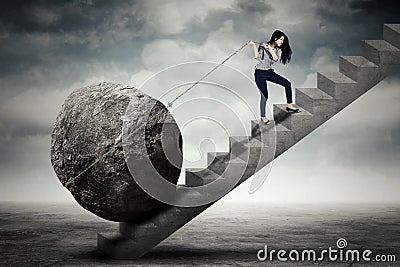 Female entrepreneur carrying big stone on the stair Stock Photo